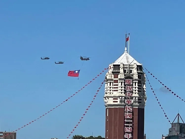 114年國旗大會今天隆重登場，陸軍一架CH-47SD契努克重型直升機吊掛巨幅國旗，伴隨2架UH-60M黑鷹直升機飛越總統府前方廣場上空，有民眾拍下國旗總統府同框的精彩畫面。讀者提供