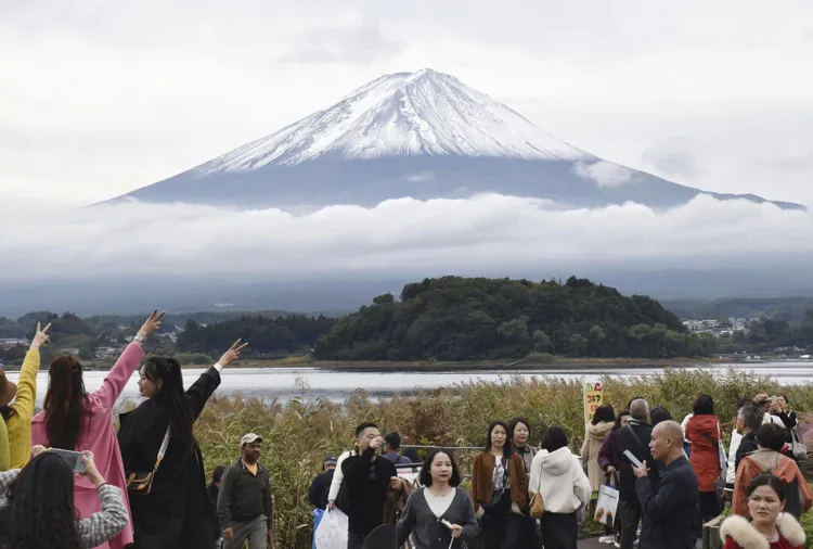 遊客在山梨縣欣賞富士山初冠雪美景。路透