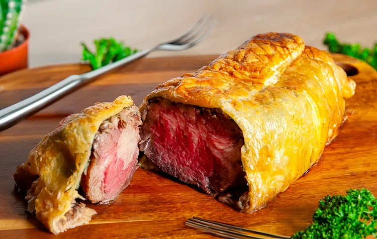 「威靈頓牛排」因饕客強烈敲碗回歸，酥皮包裹粉嫩牛排，一刀切開香氣四溢，是節慶餐桌上最具儀式感的經典菜色。台北凱撒大飯店提供