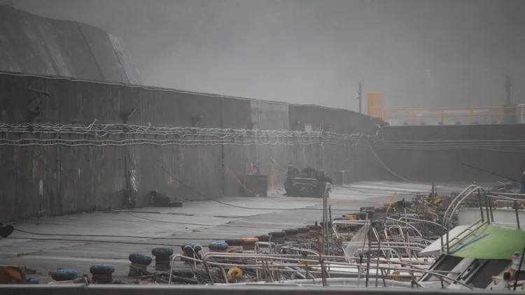 一輛停放在防坡堤的黑色轎車遭巨浪砸翻。葉先鵬攝