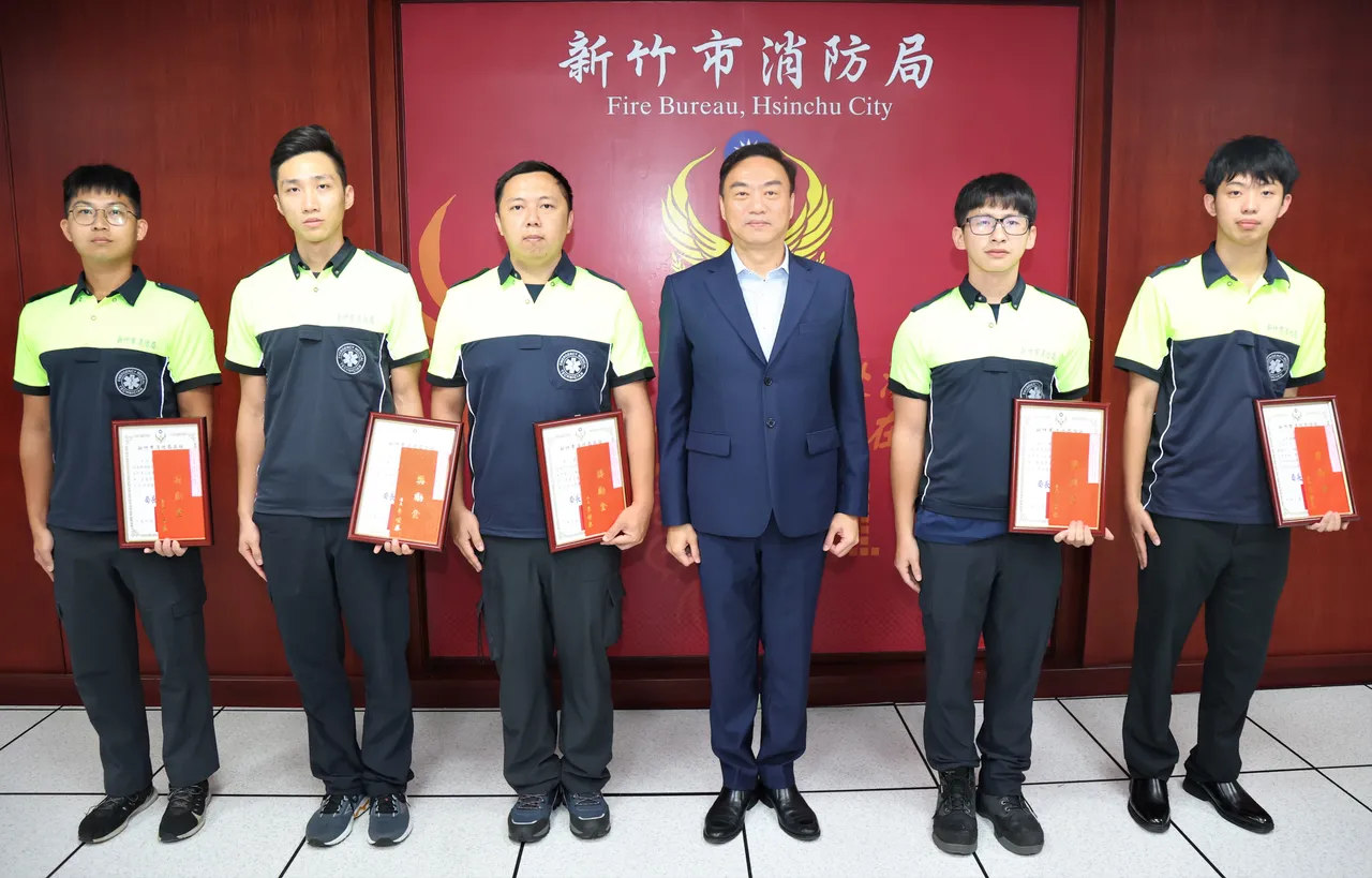 消防局长李世恭颁发感谢状予勤务派遣科执勤员简伯祐(右)及香山分队4名消防员。新竹市府提供
