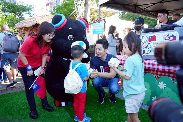 2至12歲兒童憑數位卡可免費領取鮮乳，家長帶孩童排隊領取，現場洋溢笑聲。北市府提供