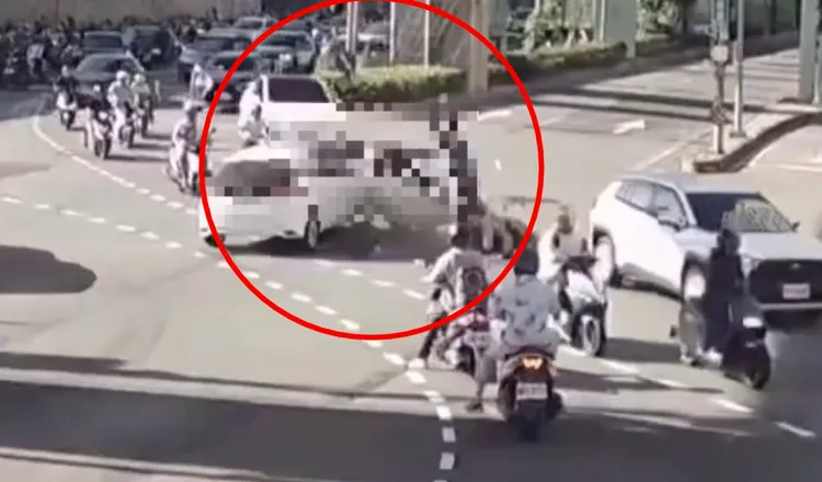 蔡女駕駛白色汽車衝入左轉車流，撞飛整排機車，畫面相當驚悚。翻攝畫面