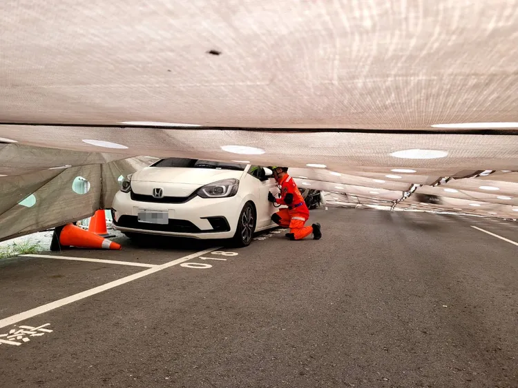 倒塌的鷹架壓住汽車，消防人員查看是否有人受困。民眾提供