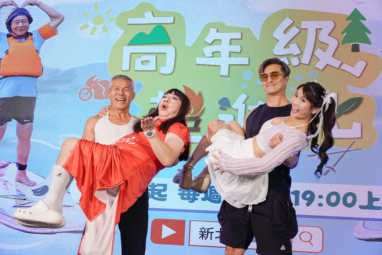 艺人王少伟(右一)现场与银发俱乐部长者大比肌力,现场公主抱「董月花」(左一)稳若泰山。社会局提供