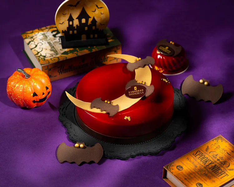 台北遠東香格里拉「緋紅暗月胡桃蛋糕」，鮮紅透亮的鏡面搭配巧克力新月與飛舞蝙蝠點綴，營造出魔幻又神秘的萬聖節氛圍，7吋1680元。台北遠東香格里拉提供