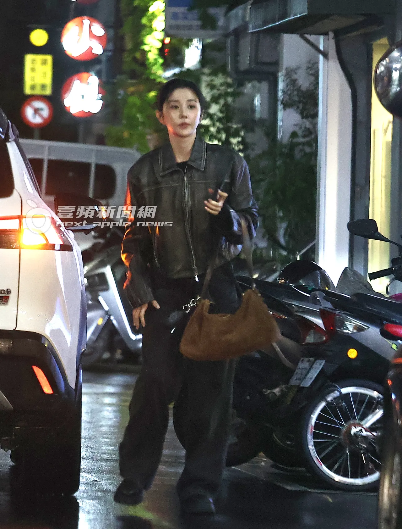邵雨薇身穿酷帅皮外套,搭配黑裤及黑鞋,手提咖啡色包包。特勤中心摄