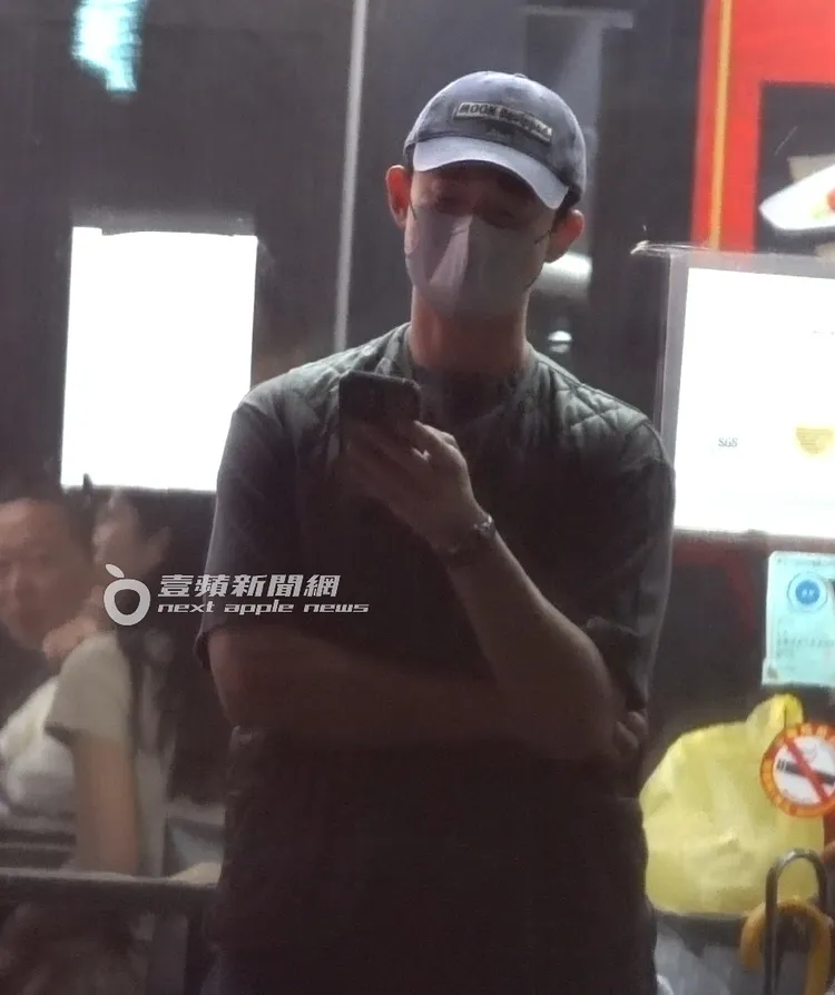 吳慷仁在等餐期間，不停滑手機。特勤中心攝。