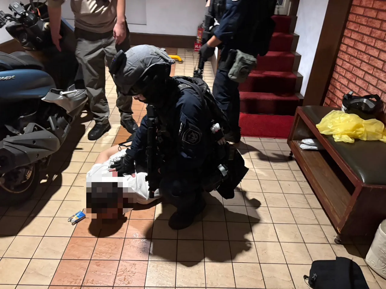 新庄中环路三段发生一起枪击案,李姓男子颈部中弹身亡。警方在三重区某汽车旅馆攻坚逮捕犯嫌3人。警方提供