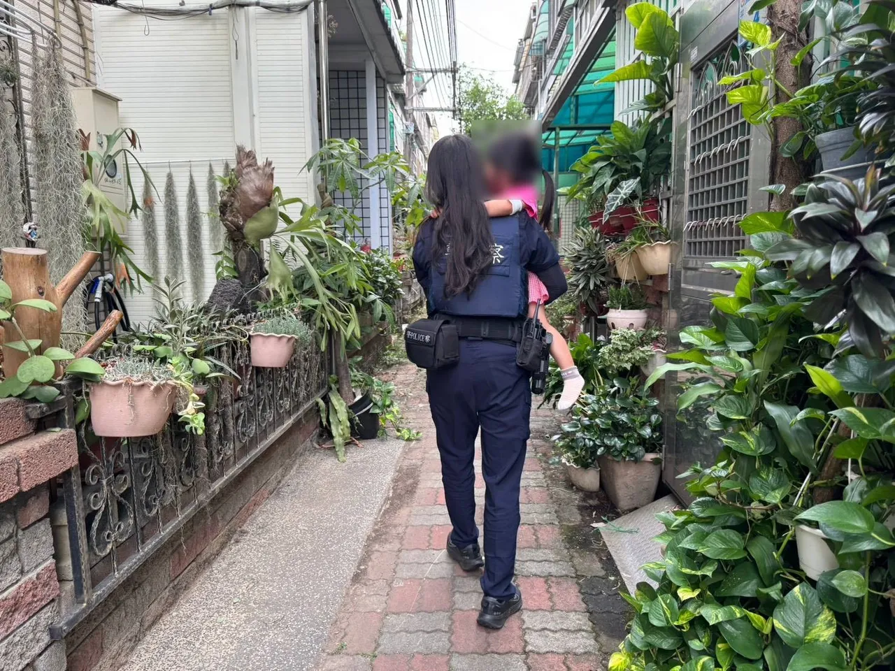 女警抱著女童挨家挨户找寻家人。平镇警分局提供