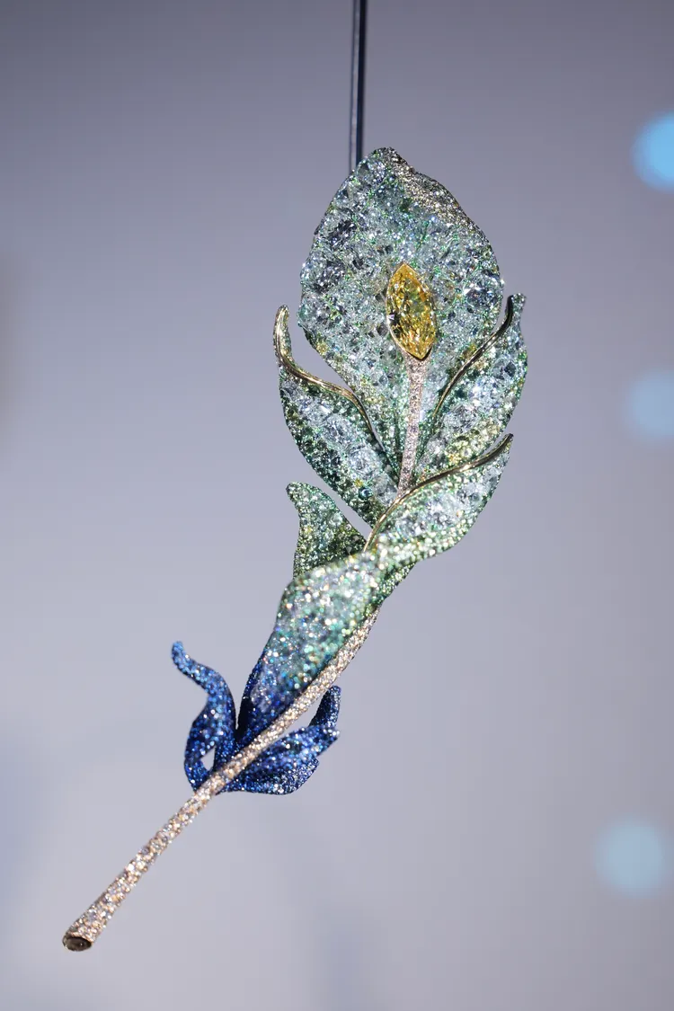 二十周年系列羽毛胸針，主石3克拉馬眼切割濃彩黃鑽，配石白鑽、黃鑽、偏灰綠色藍寶石、藍寶石、偏灰藍寶石、沙弗萊石，材質鈦金屬，共3693顆寶石，總重78.51克拉。彭欣偉攝