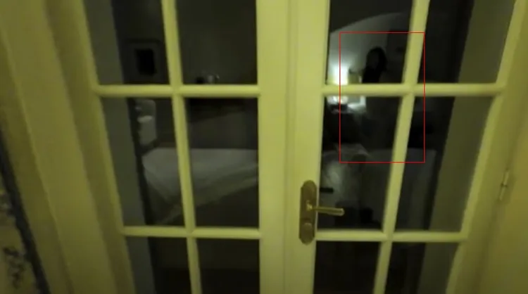 金鍾國介紹飯店房間時，玻璃門照映出一名女子的身影，疑似就是他的老婆。翻攝YouTube