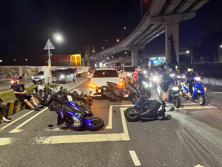 賓士車撞進待轉區，5輛機車東倒西歪，受傷機車騎士無奈坐在一旁等待救援。翻攝畫面