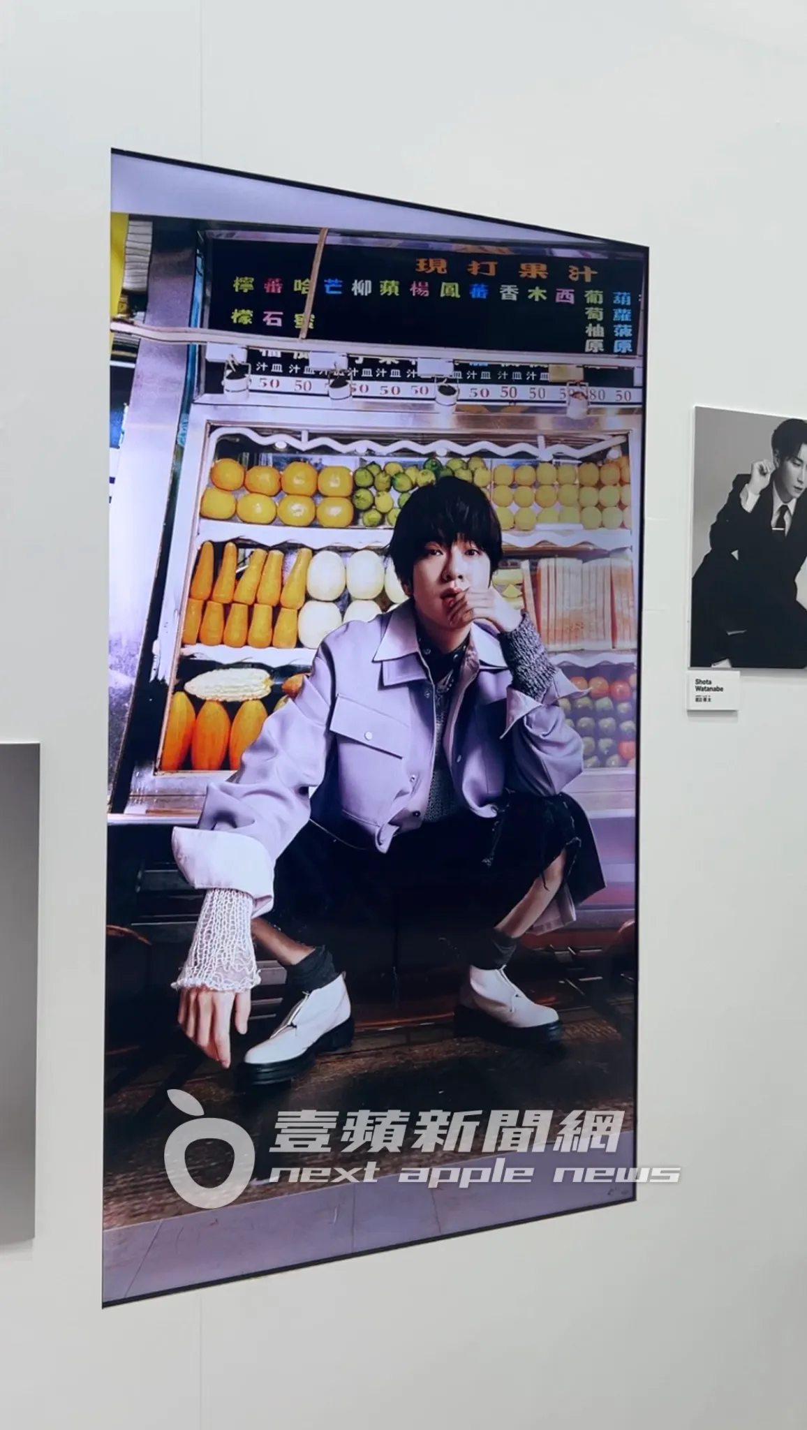 動態照片牆展示以台北街景為背景的照片,深澤辰哉站在水果攤背景前拍照。陳薇安攝