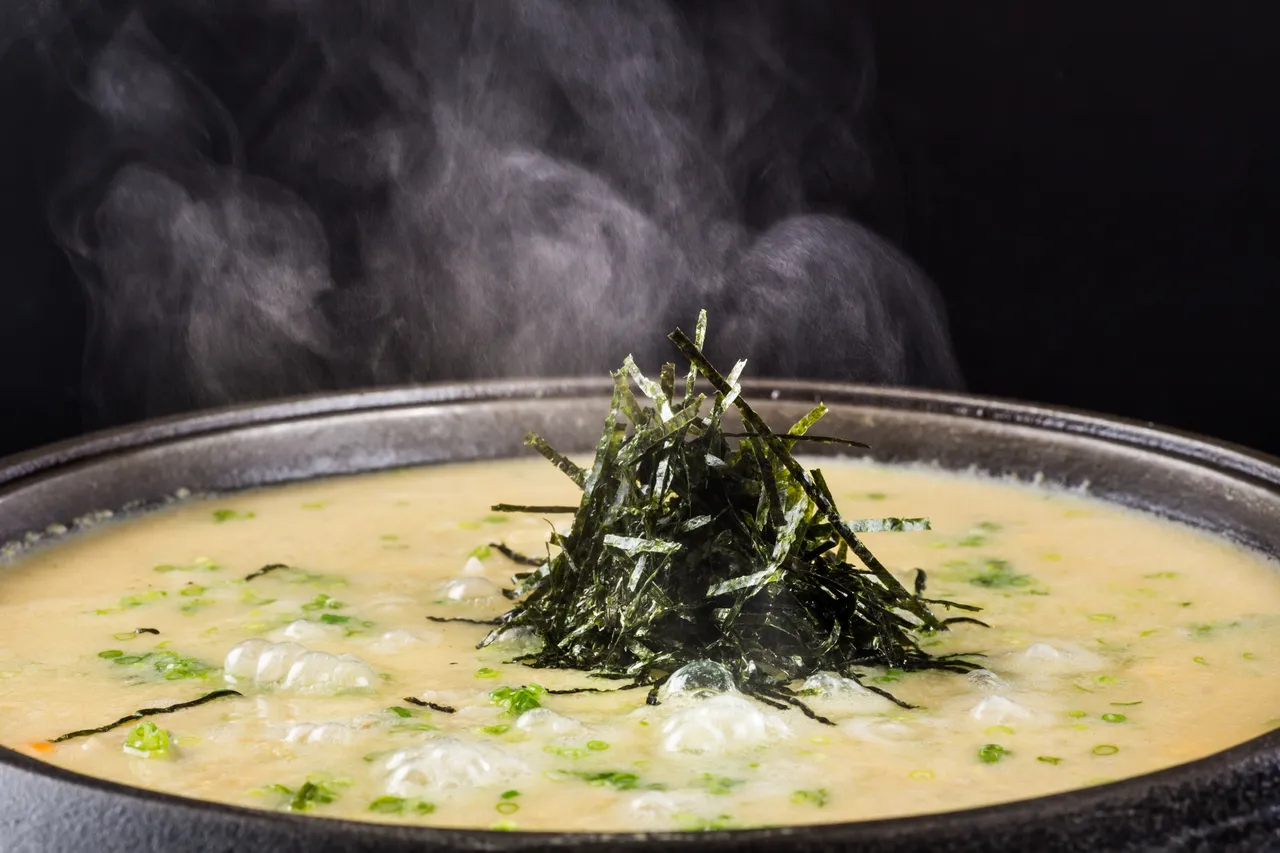 三燔本家推出的「顶级鳕场蟹飨宴」中,压轴登场的鳕蟹膏杂炊是将蟹锅精华汤底加入喷香米饭与浓郁蟹膏一同熬煮,起锅前淋上蛋液并洒上海苔丝及葱花,美味而充满饱足感。台北晶华提供