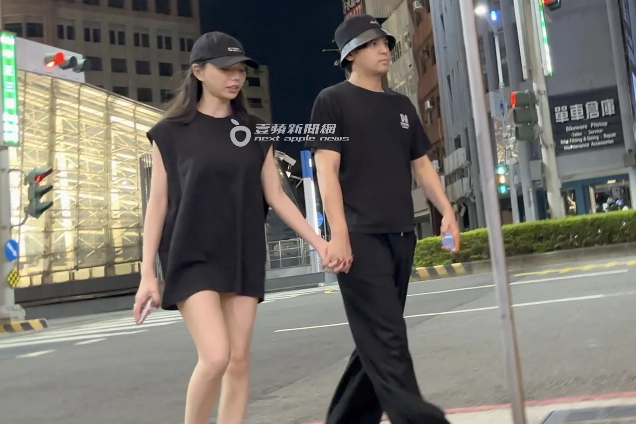 陈零九(右)与JKF冠军女郎啾啾十指紧扣,漫步经过高雄捷运美丽岛站。特勤中心摄