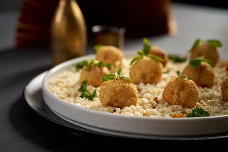 雪白木耳改良自幾乎失傳的酒家菜炸冰塊，將木耳膠質包覆在豬網油中，外型如橘子象徵吉利。台北福華大飯店提供