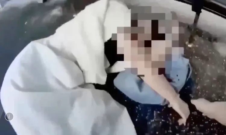 28岁女乘客下公车踩空跌倒,头部撞到公车亭内椅子晕倒地上流血,巡逻女警听闻人群骚动立刻跑来帮忙。翻摄画面