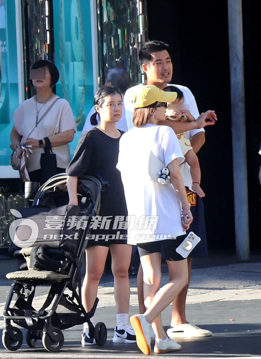 阿力(右)抱著儿子又又,李佳颖推著娃娃车,一行人在路口等号志灯。特勤中心摄