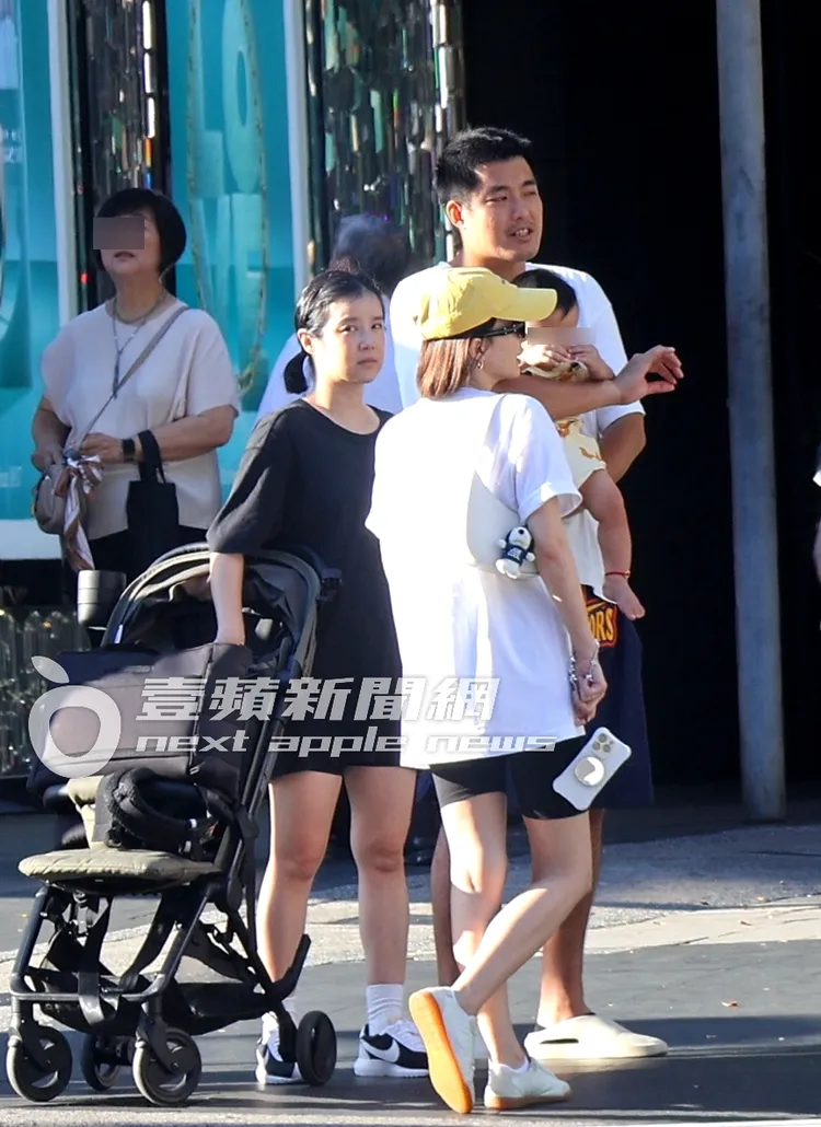 阿力（右）抱著兒子又又，李佳穎推著娃娃車，一行人在路口等號誌燈。特勤中心攝