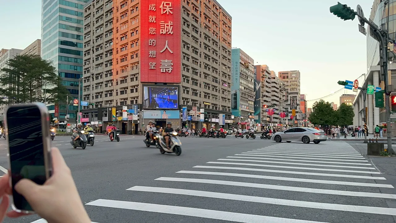 不少民眾拿起手機拍攝夏姿巴黎大秀直播。陳建岐攝