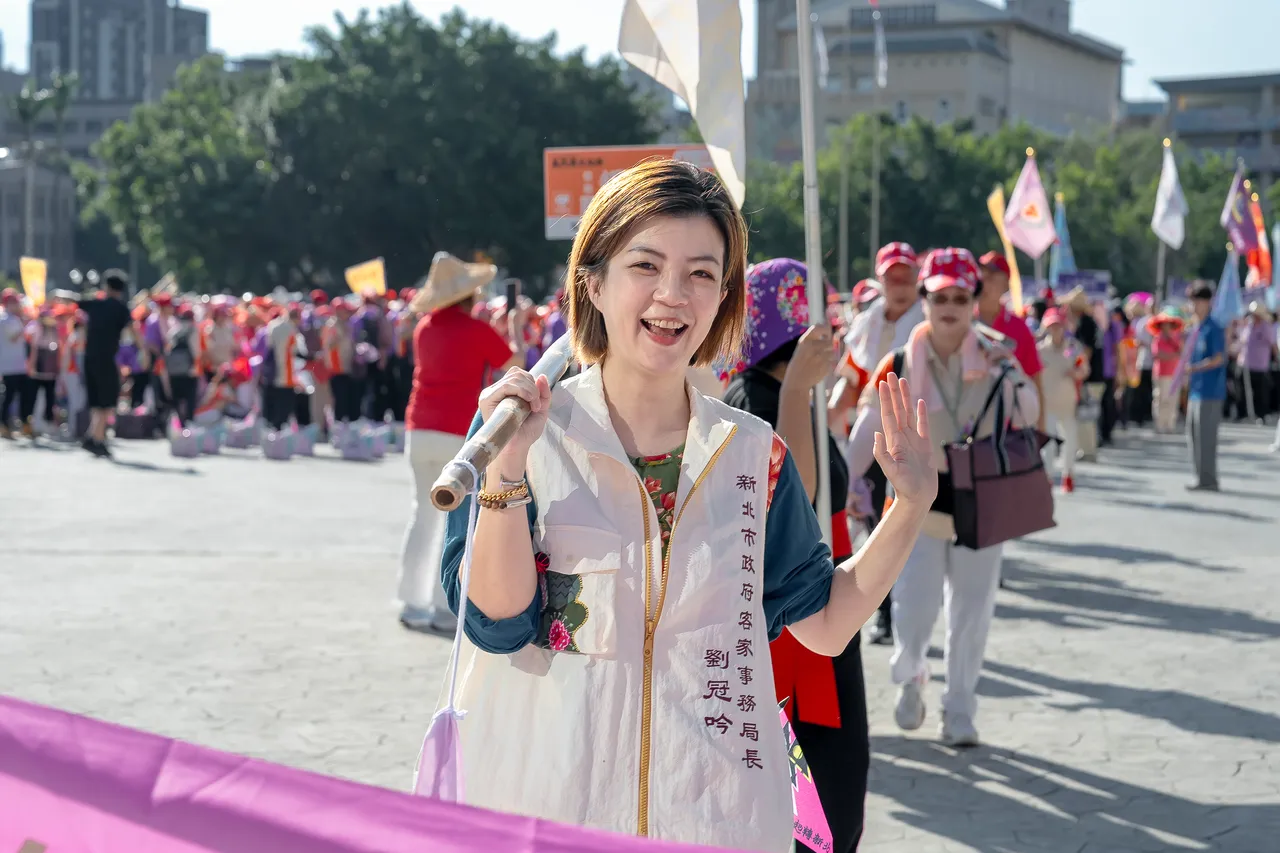 新北市政府客家事务局局长刘冠吟挑担奉饭出发。