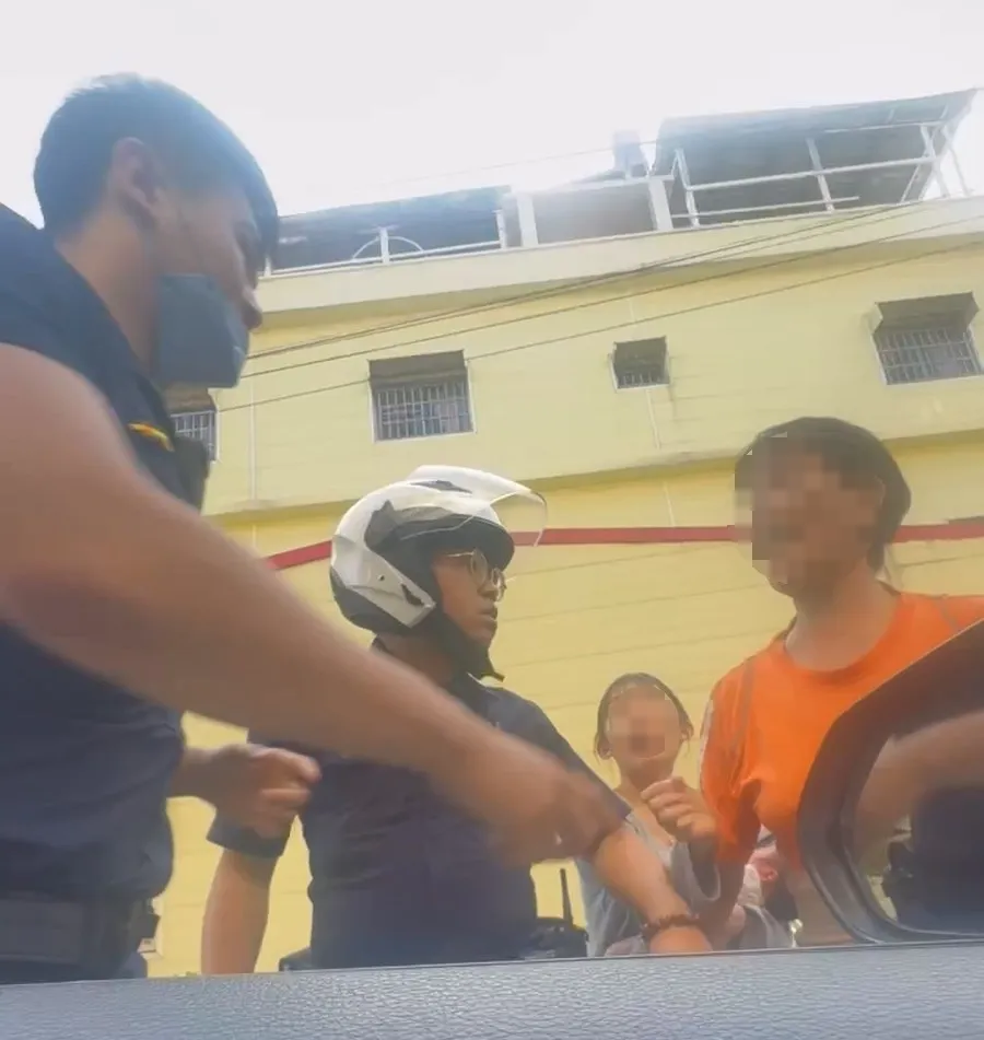 洪妇加入理论，还捉了一下警员握枪的左手，另名员警立即上前推开洪妇。翻摄画面