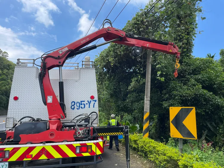 消防人員以救災車吊臂將周男拉至路邊。民眾提供