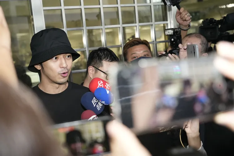 藝人陳柏霖（圖左）涉嫌閃兵，新北檢訊後諭令50萬元交保，面對媒體脫下口罩微笑受訪。彭欣偉攝