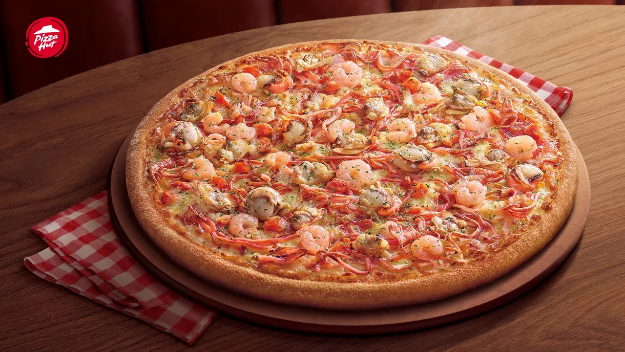 上市35年的「海鲜比萨」用料升级,使用帆立贝搭配鲜虾、蛤蜊与蟹味丝,打造出「海鲜四重奏」。必胜客提供