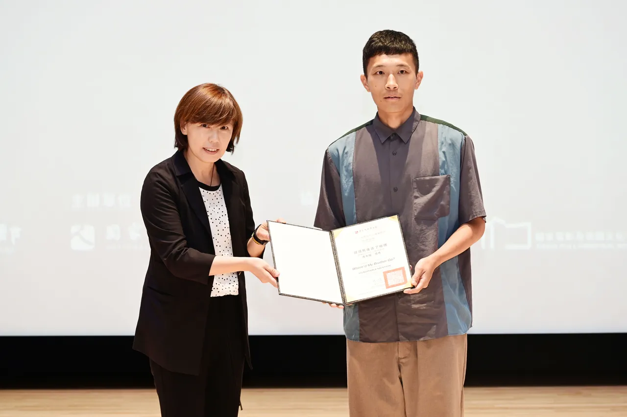 楊正欣導演(左)將青年組佳作頒給《哥哥死後去了哪裡》導演陳俊維。臺灣國際人權電影節提供