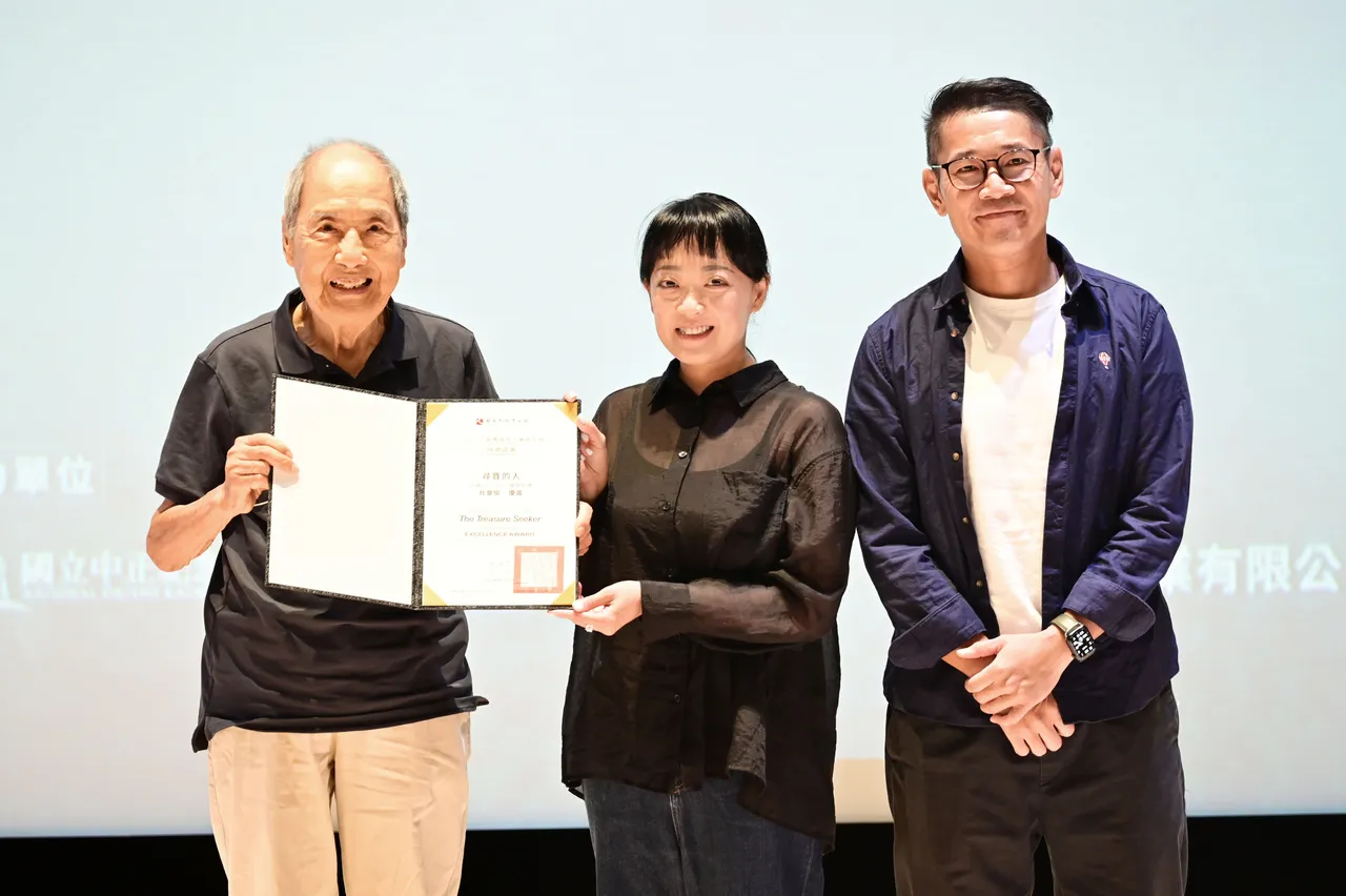 前台大教授張則周(左)頒發社會組優選獎給《尋寶的人》導演蔣煥民、孫曉彤。臺灣國際人權電影節提供