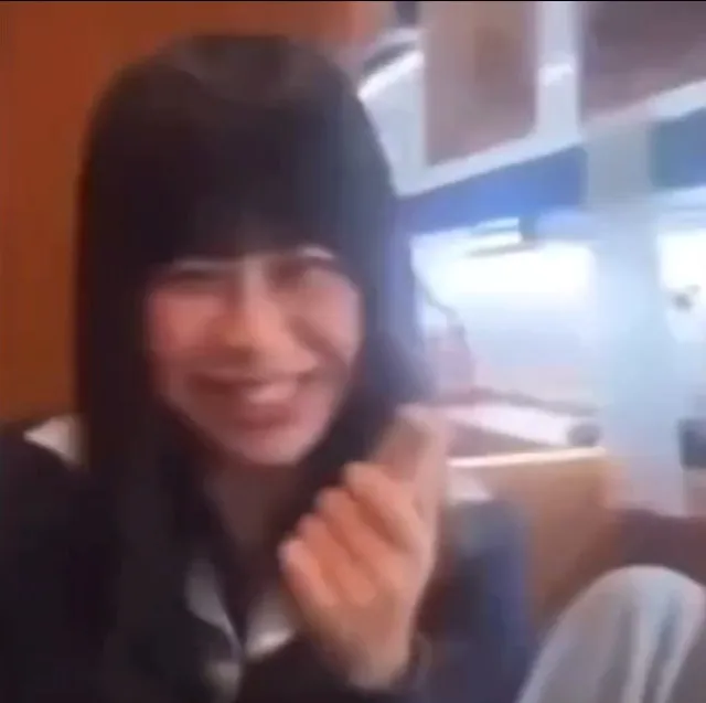 女學生疑似以口觸碰醬油瓶後露出得意笑容。