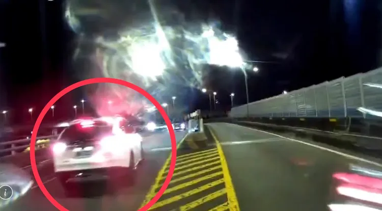 白色休旅車逆向誤下新北大橋匝道，在警方協助下，安全退回橋上後，於分流處開往正確道路。翻攝畫面