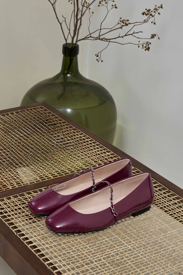 瑪莉珍芭蕾舞平底鞋以頂級漆皮搭配金屬鍊條裝飾鞋帶。品牌提供