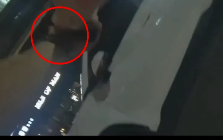 警員用機車攔住白色小客車，並衝下車掏槍對著駕駛大喊「下車！」。翻攝畫面