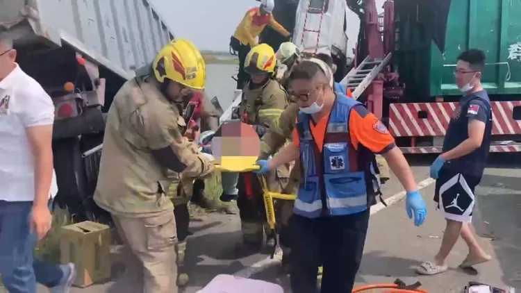 2輛大型貨車不明原因發生碰撞，1車衝入魚塭，司機受困命危送醫。翻攝畫面