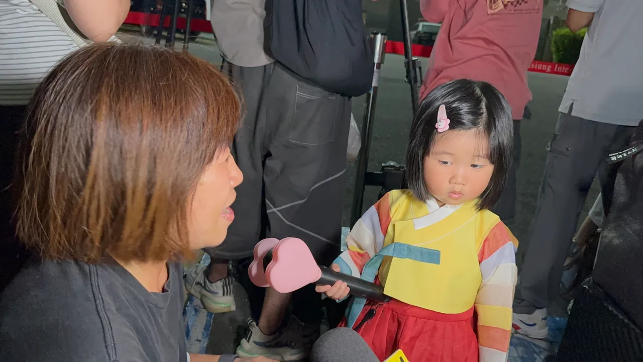 2岁半的妹妹受到姊姊的影响也穿著韩服、拿手灯,跟妈妈一起来追星。特勤中心摄