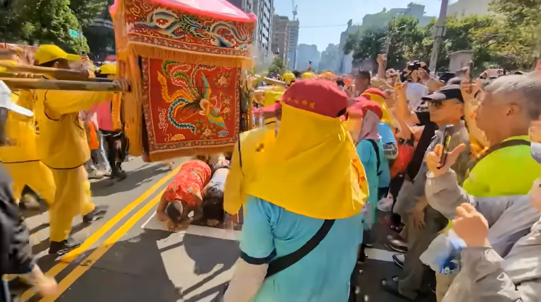 「吊车大王」胡汉䶮跪地接驾白沙屯妈祖,并顺利钻轿底领福。翻摄《白沙屯妈祖网路电视台》YouTube