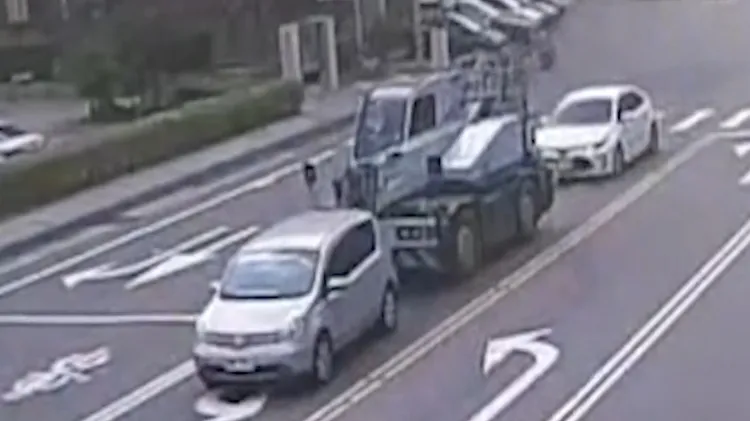吊車未注意前方狀況，吊臂插進轎車後座。翻攝畫面