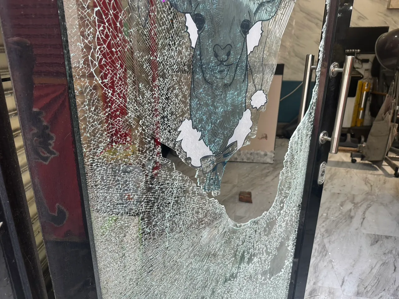 店门被砖头砸破。警方提供