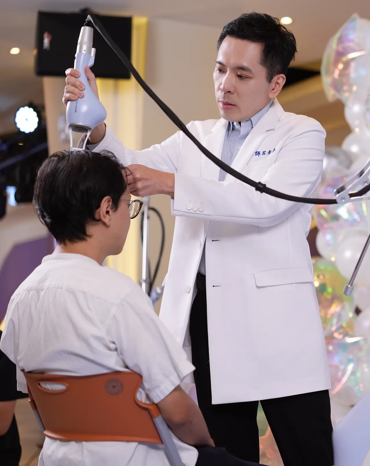 吕彦杰医师示范操作拉发密雷射。彭欣伟摄
