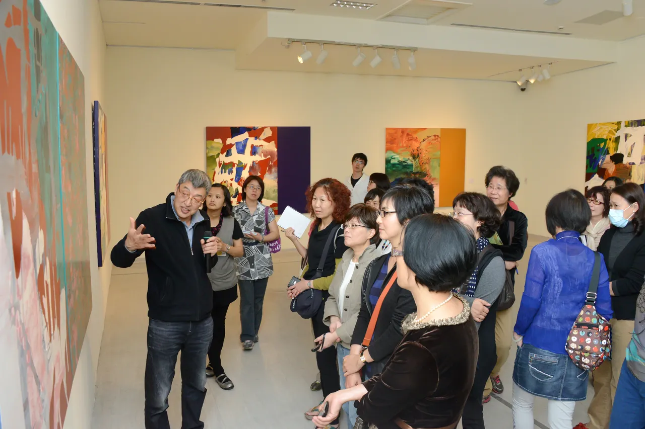 國立台灣美術館於2013年舉辦「形形色色-曲德義個展」,藝術家曲德義(左1)為參展貴賓導覽。文化部提供
