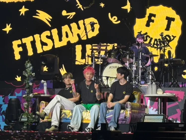 李洪基（中）要隊友李在真（左）、崔敏煥（後）、客座吉他手集合，學中文「在台灣最有名的樂團」，台下大喊「FTISLAND」。讀者提供