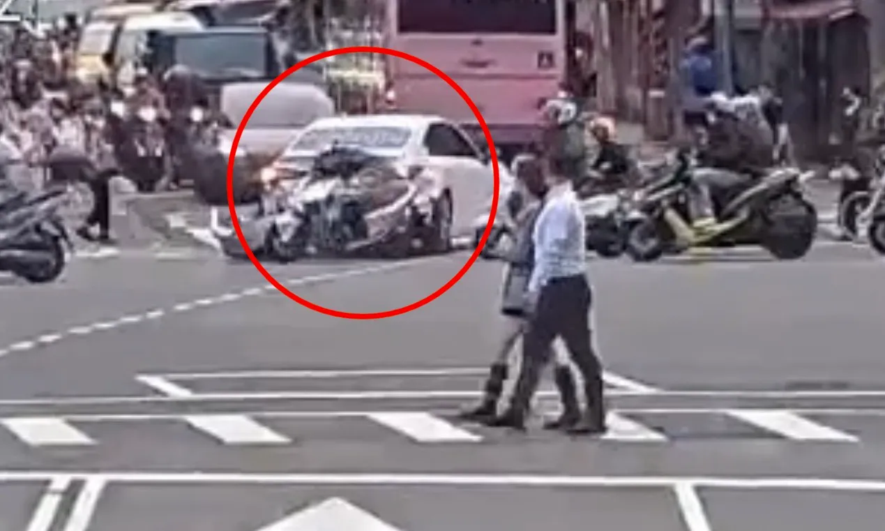 第一輛機車撞到白色小客車右後車尾後,再波及另一輛機車,路人聽到碰撞聲響也回頭查看。翻攝畫面