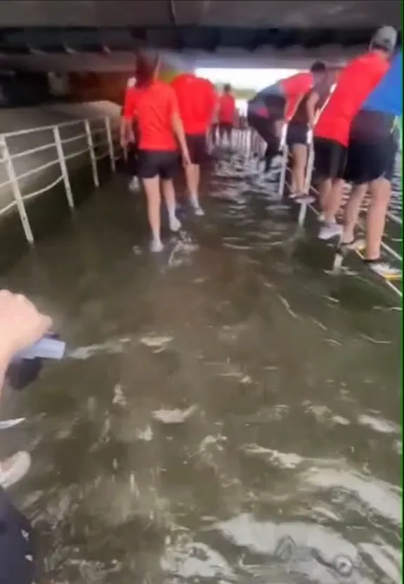 不少人选择爬栏杆通过深水区。翻摄照片