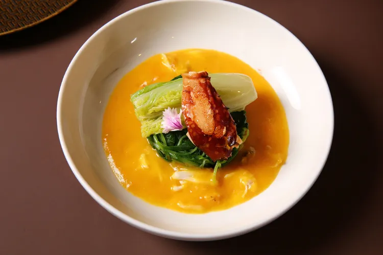 台北萬豪宴客樓「金秋饗蟹」，「蟹香田園灼時蔬」則以蟹膏、鹹蛋黃、花雕酒炒製的蟹粉醬燉煮時蔬，鋪上娃娃菜和蟹臂。業者提供