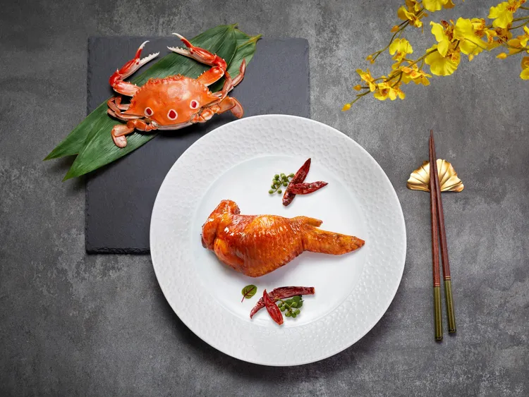 望月樓主廚邱龍俊的巧手之作「巴蜀。蟹肉。脆皮翅」，工序繁複，將鮮濃蟹肉糯米飯釀入雞翅，外皮酥脆、內餡豐腴。台北遠東香格里拉提供