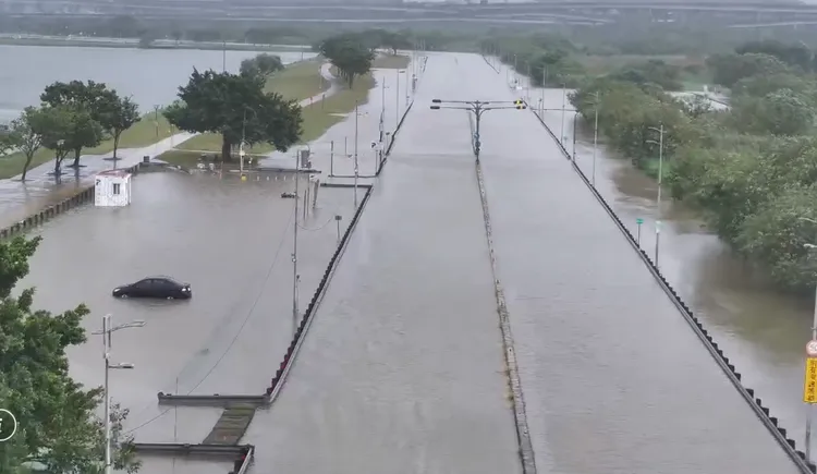 二重疏洪道停車場車輛遭殃，積水高度淹超過半個輪胎。翻攝畫面