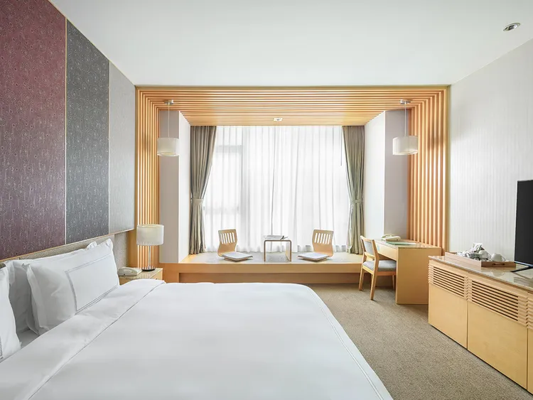 長榮鳳凰酒店（礁溪）高級洋式客房以溫潤木質打造療癒空間。一泊二食原價2萬850元，旅展限時優惠僅8388元，再享買七張送純住房住宿券一張，星級溫泉假期輕鬆入手。長榮鳳凰酒店（礁溪）提供